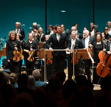 Musiker:innen des Tiroler Symphonieorchesters Innsbruck mit Dirigent Gerrit Prießnitz