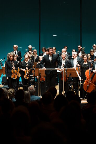 Musiker:innen des Tiroler Symphonieorchesters Innsbruck mit Dirigent Gerrit Prießnitz